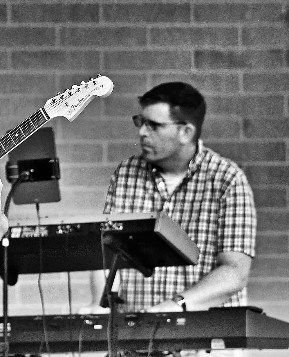 Steve playing keyboards on stage with a band