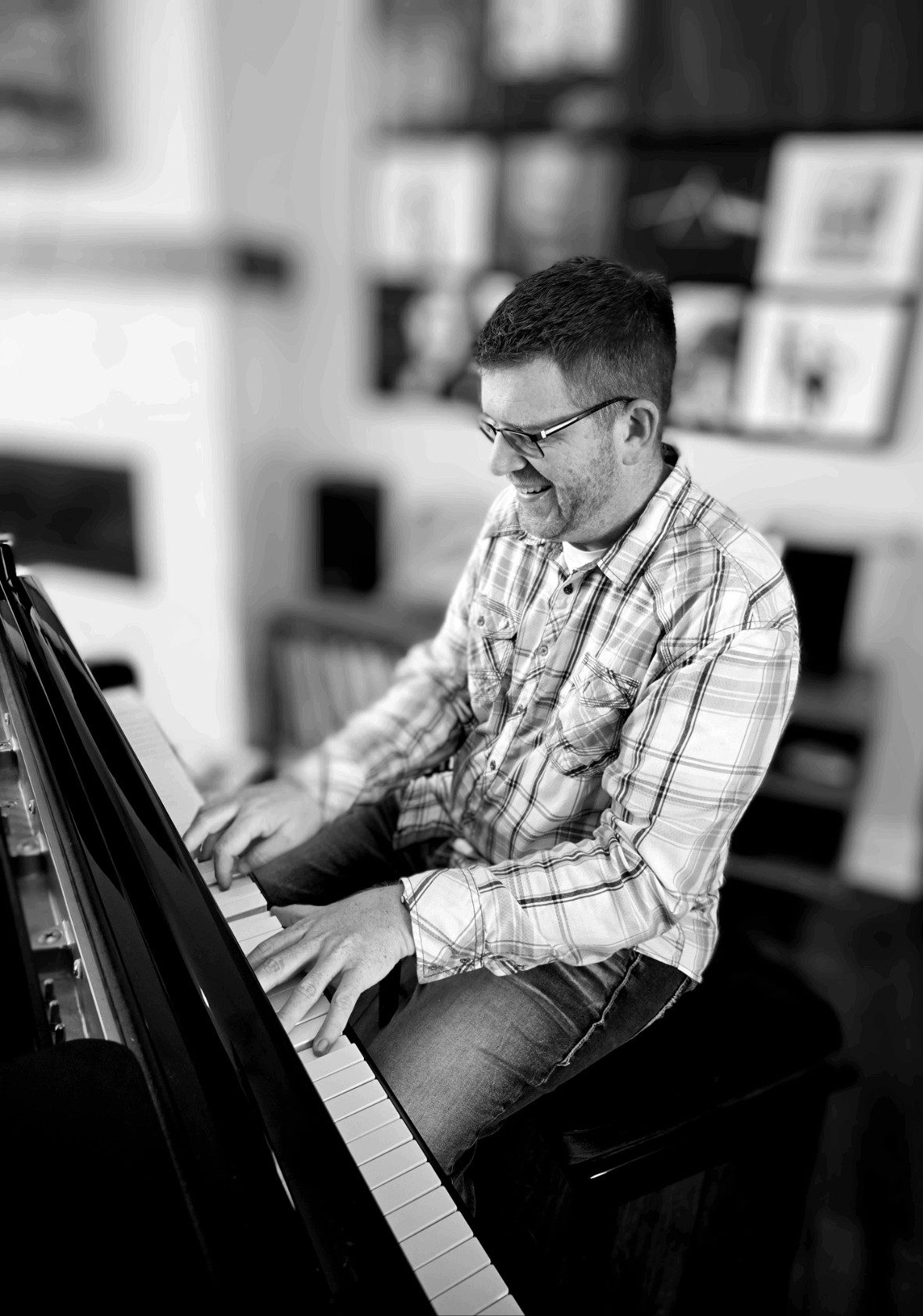 Steve smiling while playing a grand piano